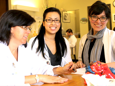 Michelle Medina (der.) posa con estudiantes en el Acupuncture & Integrative Medicine College (AIMC) en Berkeley.