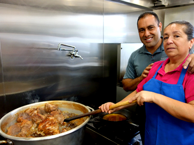 Bertha Solorio y su hijo Antonio preparan carnitas – platillo por el que es conocida su taquería Tacos Uruapan en Hayward.