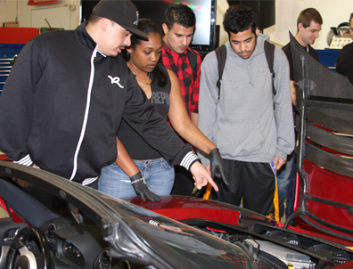 Chabot College students Emanuel Ruiz, Jessica Hollie, Faizan Fedaie, and Theron Reyes look under the hood of an electric Tesla roadster during Tesla Motors’ visit to the college’s Hybrid Auto Technology class. Students will be pursuing technical careers related to the newest hybrid and electric cars.