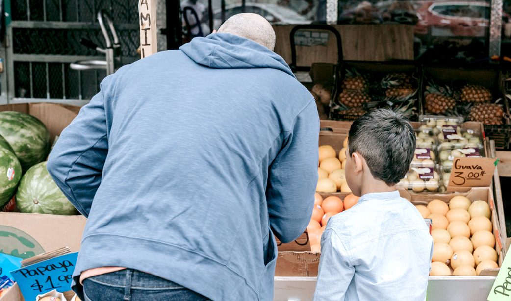 Padre e hijo compran frutas y verduras en un mercado