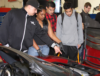 Los estudiantes de Chabot College Emanuel Ruiz, Jessica Hollie, Faizan Fedaie, y Theron Reyes ven bajo el cofre de un Tesla roadster eléctrico durante una visita de Tesla Motors a la clase Tecnología de Autos Híbridos. Los estudiantes ejer-cerán carreras técnicas relacionadas a los nuevos autos híbridos y eléctricos.